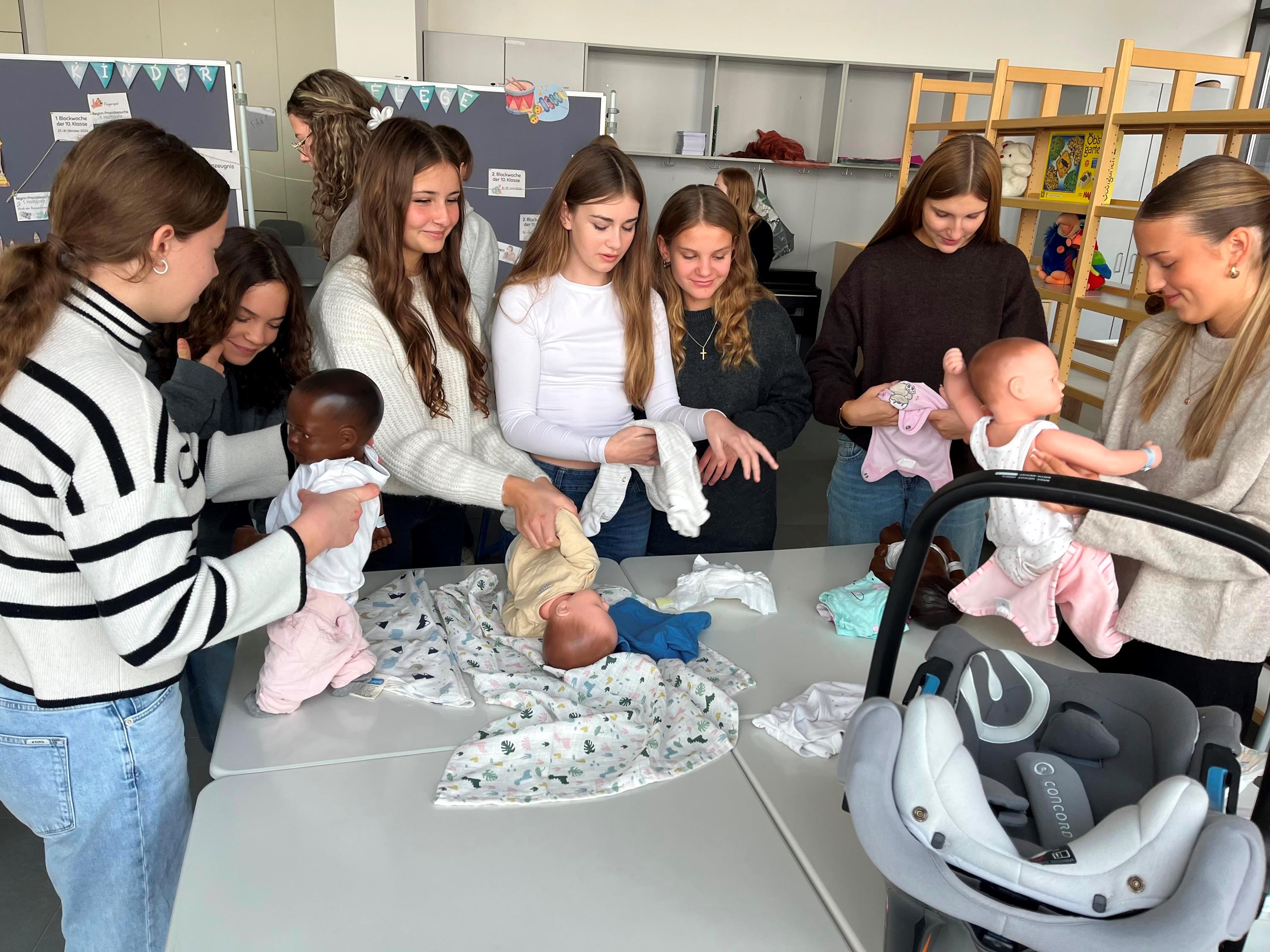Schüler üben an Babypuppen das fachgerechte Wickeln